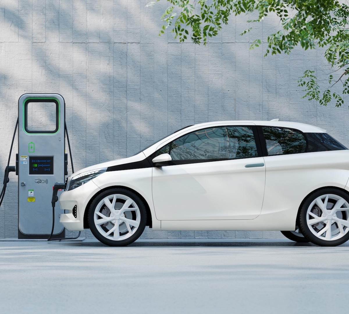 A small electric car at a charging station against a concrete wall. Car design is not based on any real vehicle